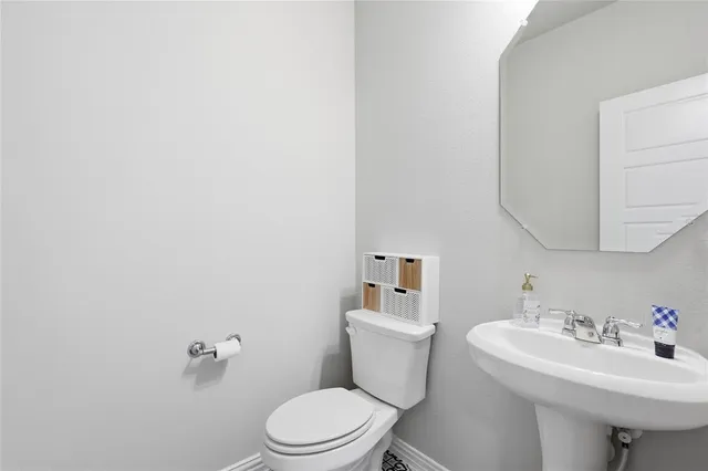 a bathroom with a sink toilet and a mirror