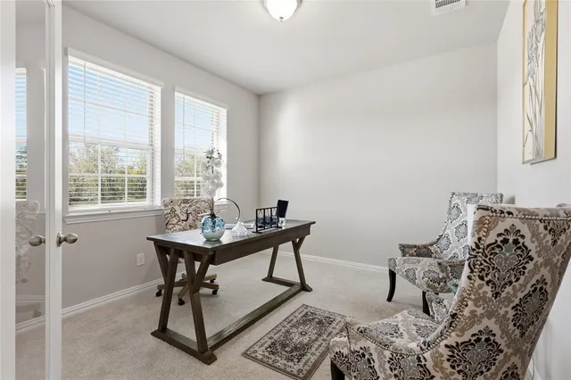 a view of a workspace with furniture and a window