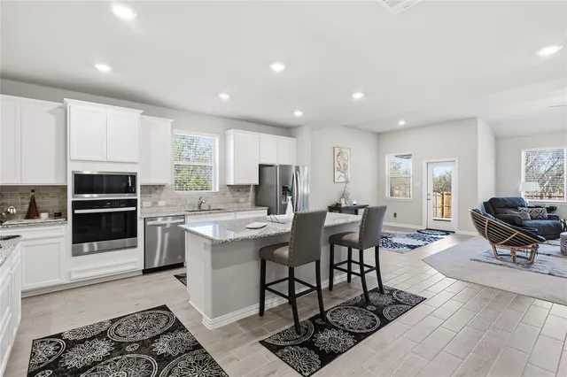 a kitchen with stainless steel appliances kitchen island granite countertop a sink and cabinets