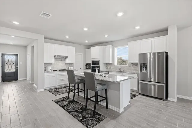 a kitchen with stainless steel appliances a refrigerator stove microwave and cabinets