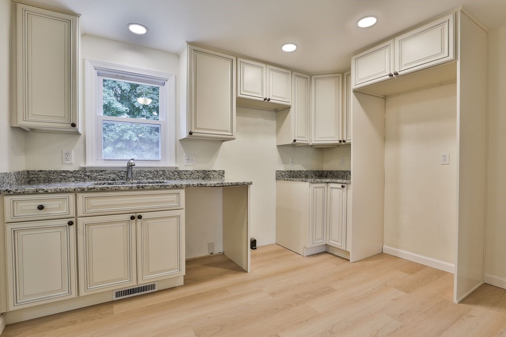 2 Morningside Drive, Unit R Derry, NH 03038 - Photo 10 of 39 a kitchen with granite countertop white cabinets white appliances a sink and a window