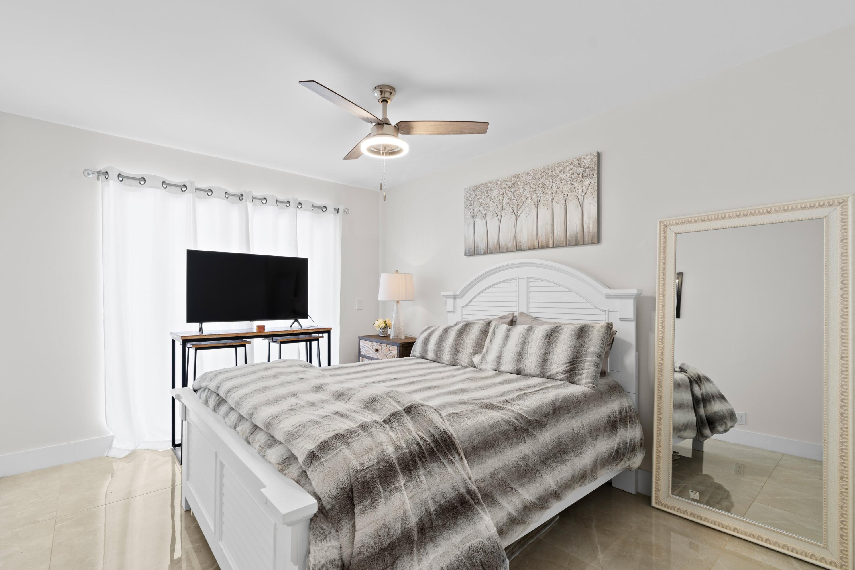 6850 Northwest 2nd Avenue, Unit 1 Boca Raton, FL 33487 - Photo 14 of 31 a bedroom with a bed and a flat screen tv