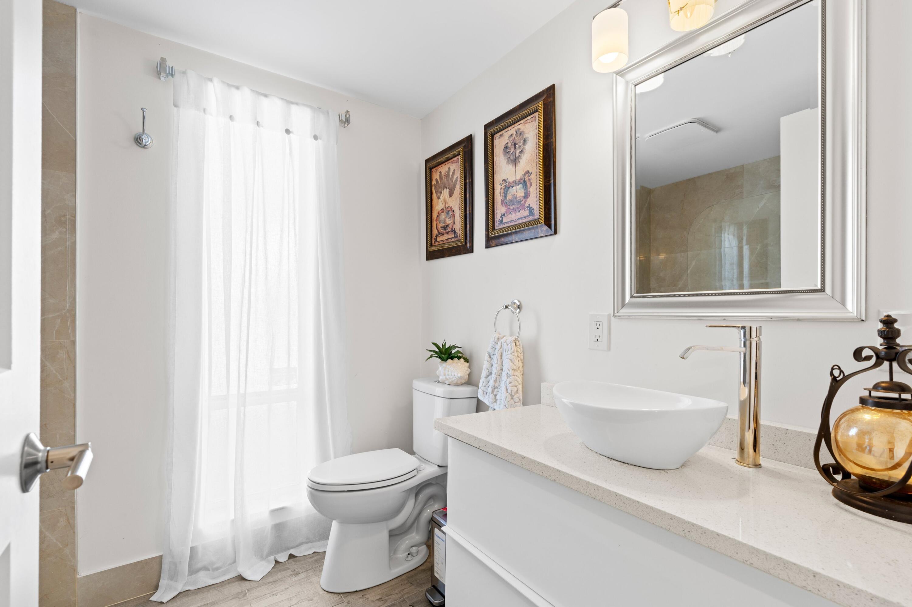 6850 Northwest 2nd Avenue, Unit 1 Boca Raton, FL 33487 - Photo 15 of 31 a bathroom with a sink a toilet and a mirror