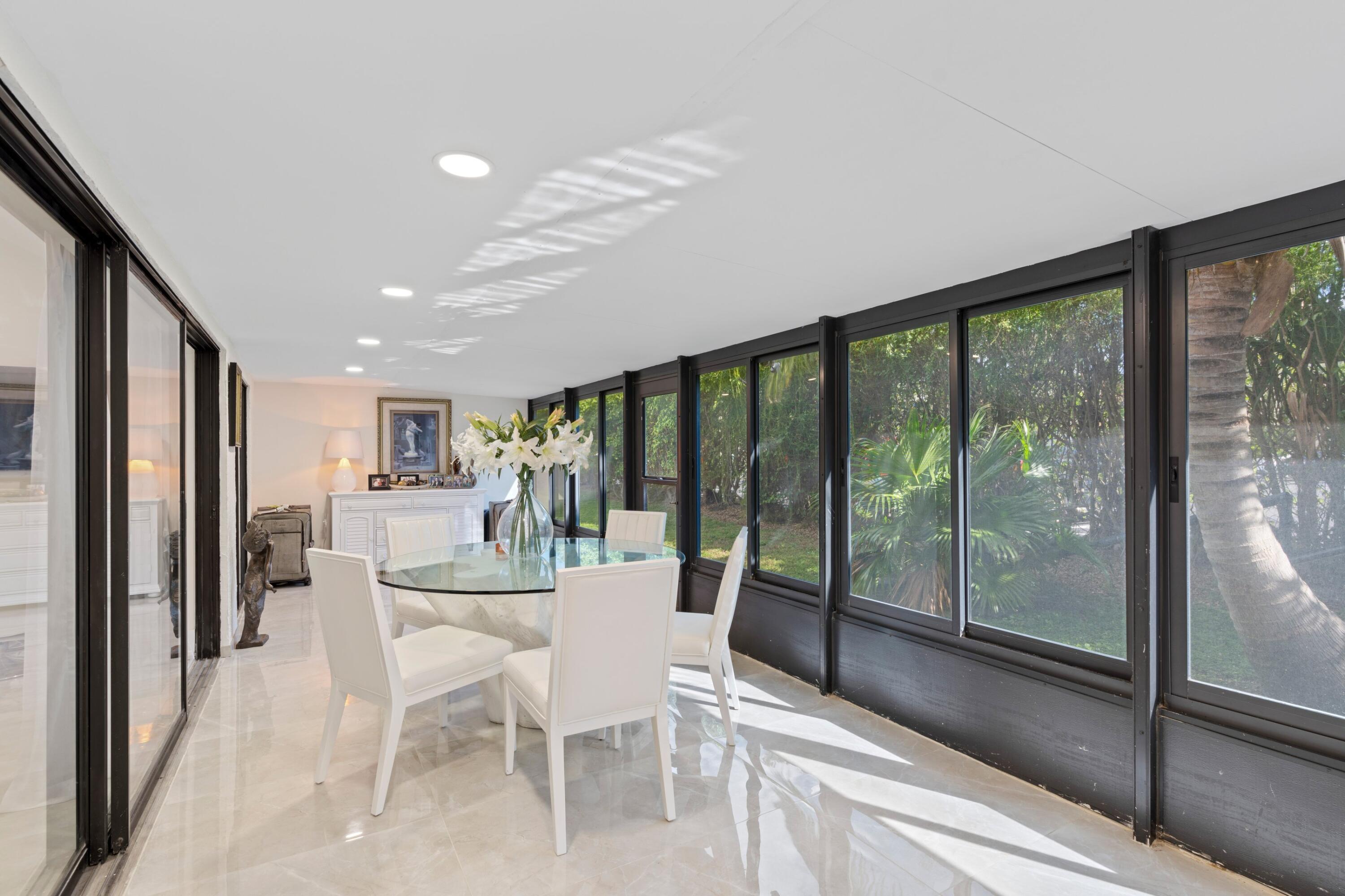 6850 Northwest 2nd Avenue, Unit 1 Boca Raton, FL 33487 - Photo 18 of 31 a dining room with furniture water view and a floor to ceiling window