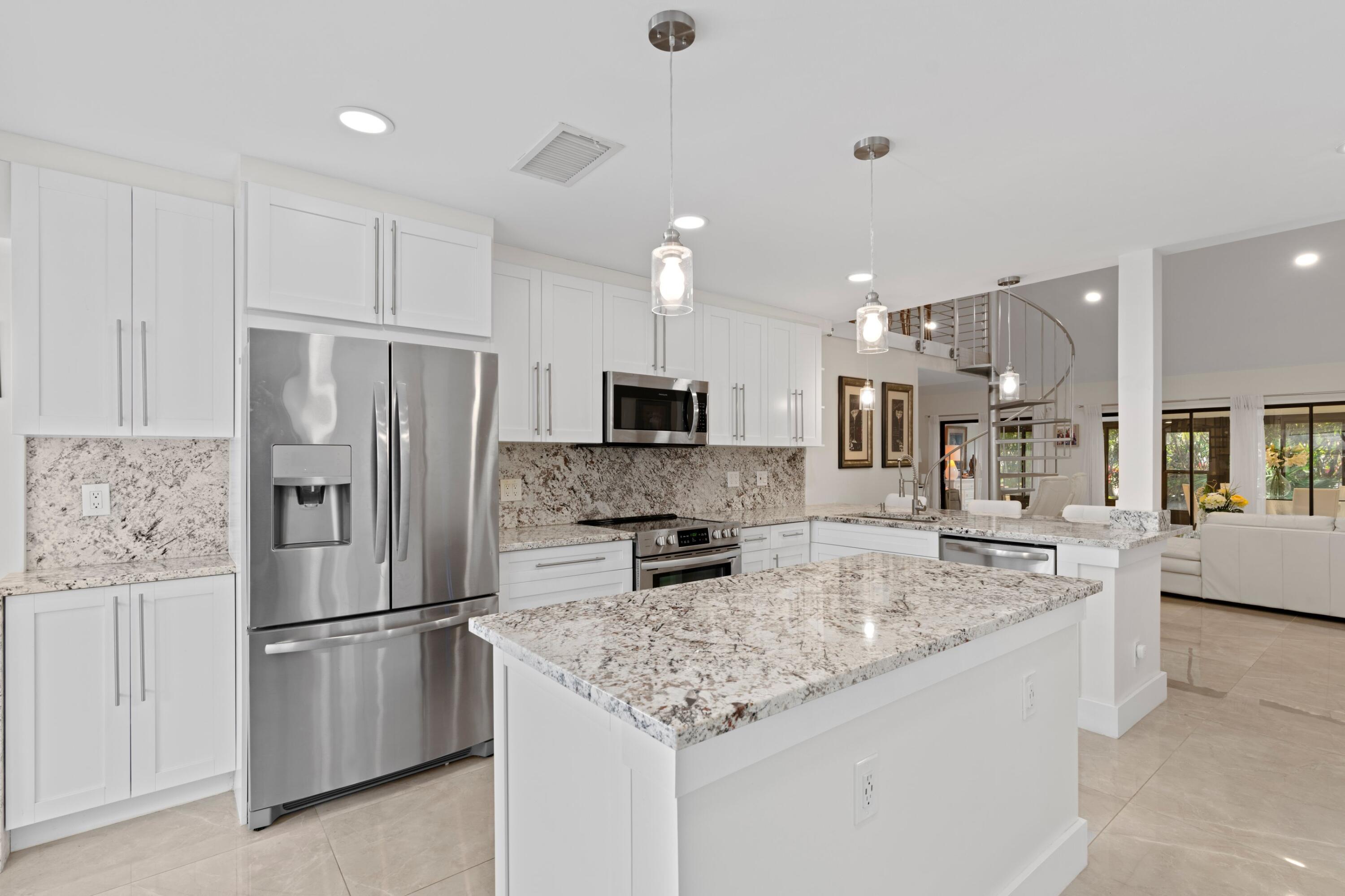 6850 Northwest 2nd Avenue, Unit 1 Boca Raton, FL 33487 - Photo 5 of 31 a kitchen with stainless steel appliances granite countertop a refrigerator and a stove top oven