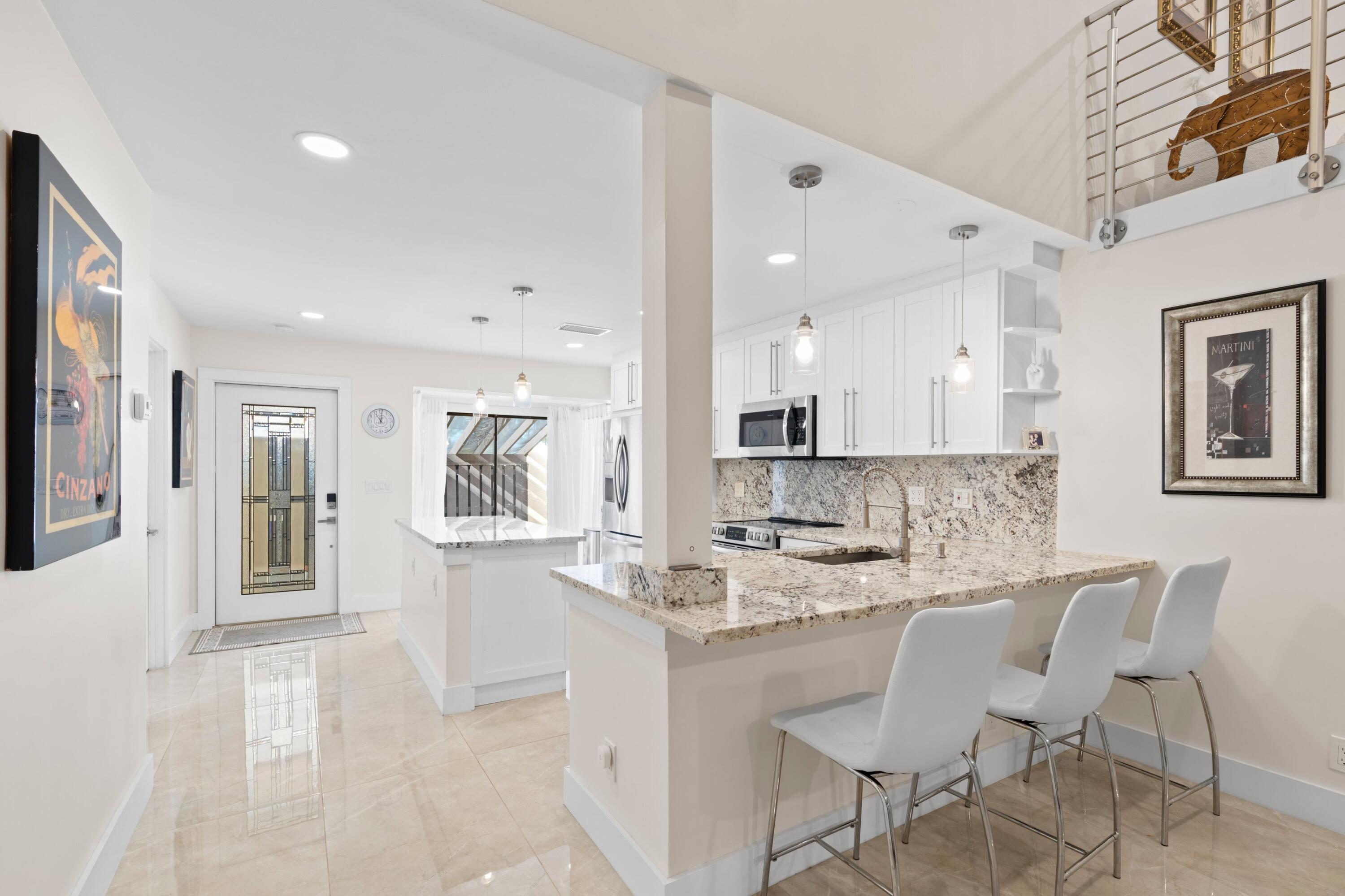 6850 Northwest 2nd Avenue, Unit 1 Boca Raton, FL 33487 - Photo 7 of 31 a kitchen with granite countertop white cabinets and refrigerator