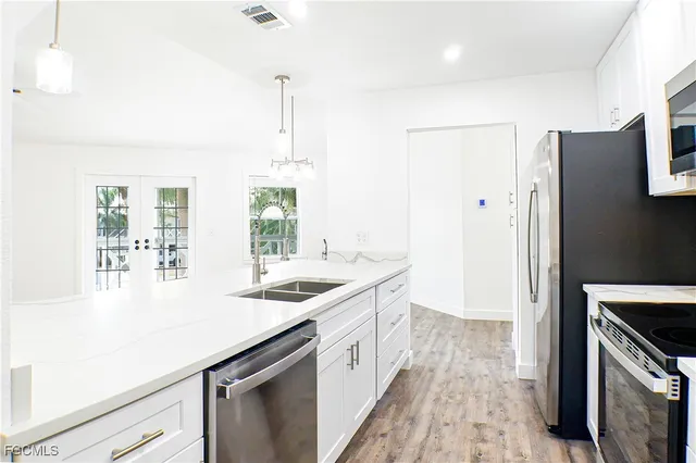 a kitchen with a sink a counter top space stainless steel appliances and cabinets