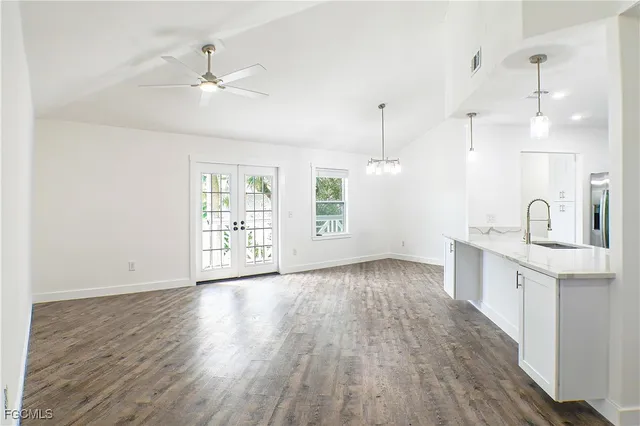 a view of a kitchen with wooden floor a sink and dishwasher