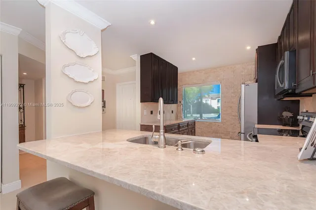 a kitchen with kitchen island a sink and a stove
