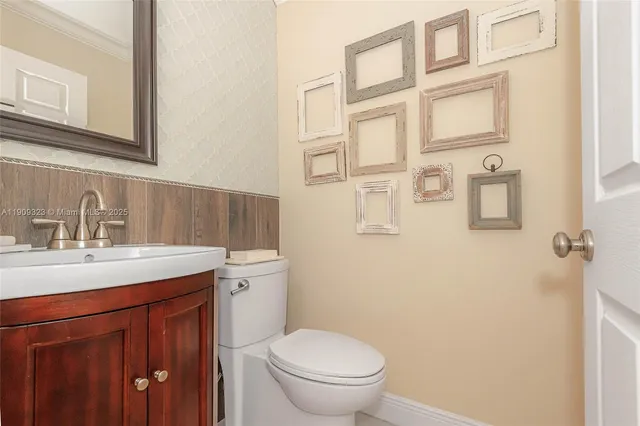 a bathroom with a granite countertop toilet sink and mirror