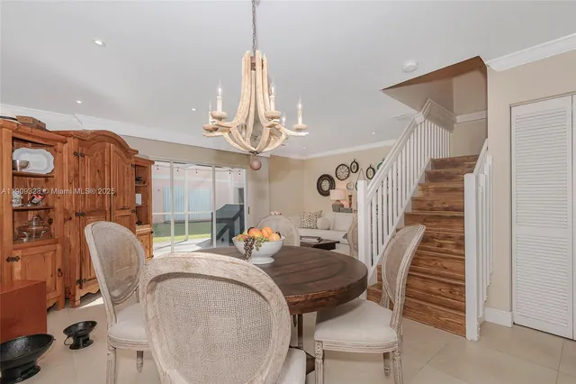 a dining room with furniture a chandelier and window