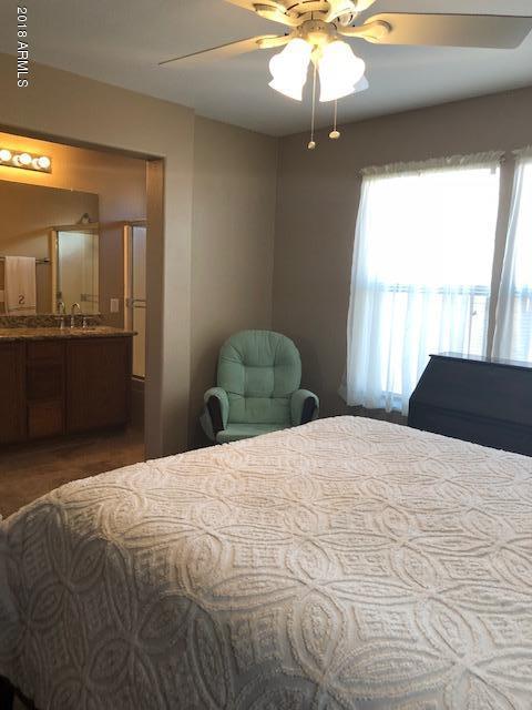 1987 East Del Rio Street Gilbert, AZ 85295 - Photo 18 of 28 a bedroom with a bed and a chandelier