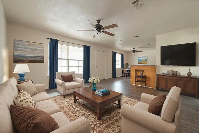 a view of empty room with wooden floor and ceiling fan