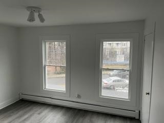 166 Rochelle Avenue, Unit 2 Rochelle Park, NJ 07662 - Photo 6 of 8 an empty room with wooden floor and windows
