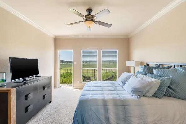 a bedroom with a large bed and a flat tv screen