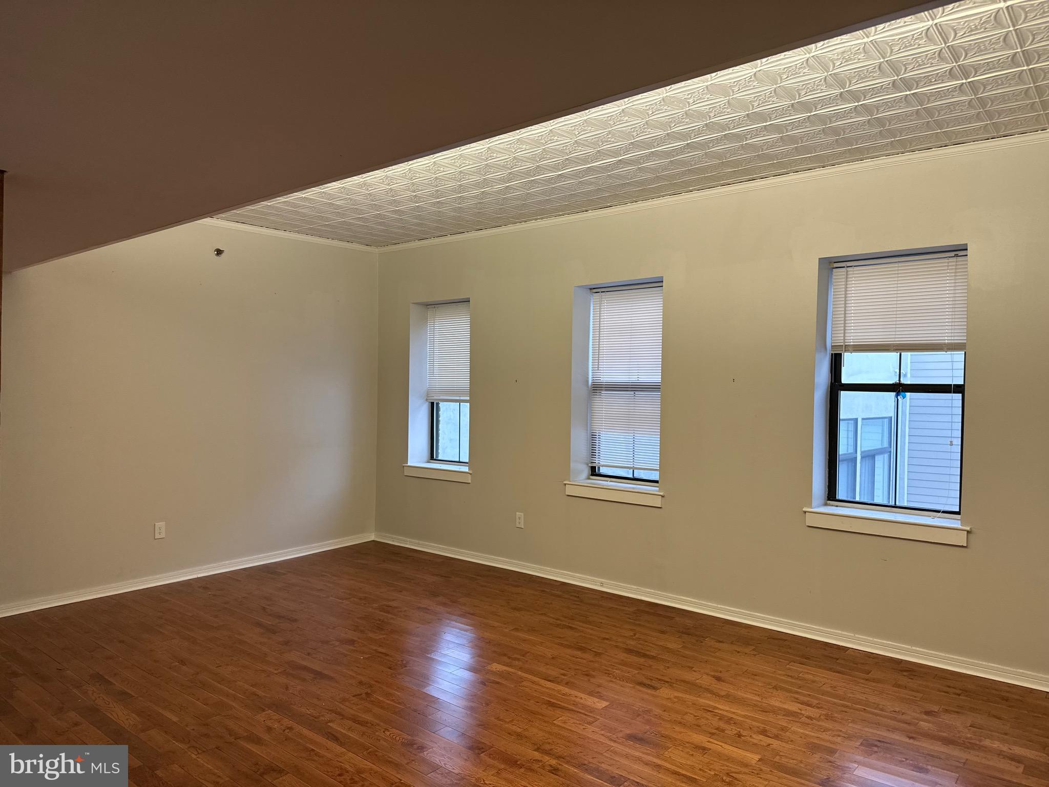 222 Church Street, Unit 5B Philadelphia, PA 19106 - Photo 5 of 15 a view of an empty room with wooden floor and a window