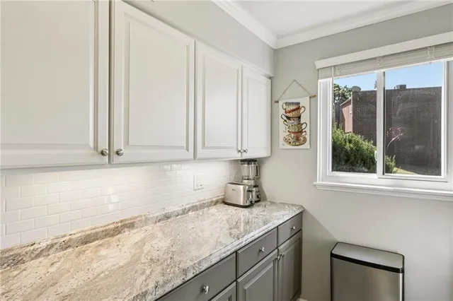 a kitchen with granite countertop a sink a window and cabinets