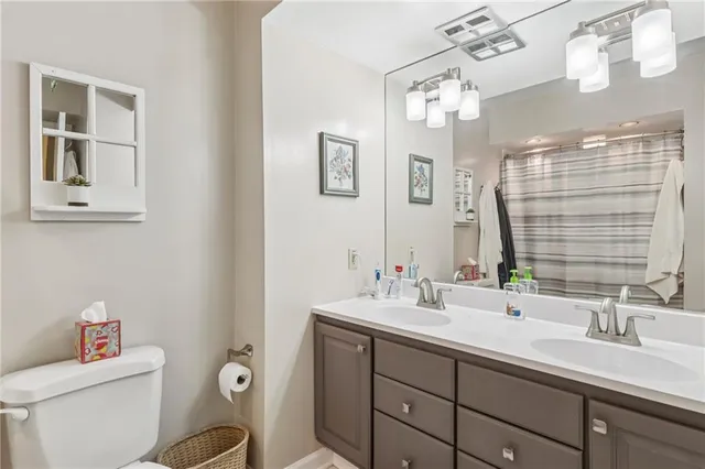 a bathroom with a sink mirror vanity and toilet