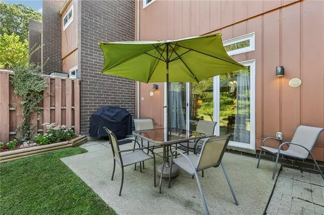 a patio with a table and chairs under an umbrella