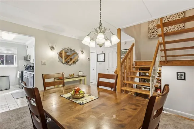 a dining room with wooden floor a chandelier a wooden table and chairs