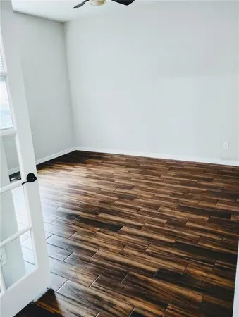 a view of a hallway with wooden floor and a livingroom