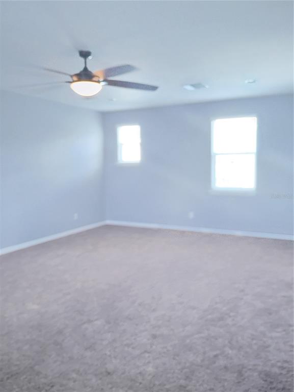 5107 Autumn Ridge Drive Wesley Chapel, FL 33545 - Photo 25 of 35 an empty room with windows and chandelier fan