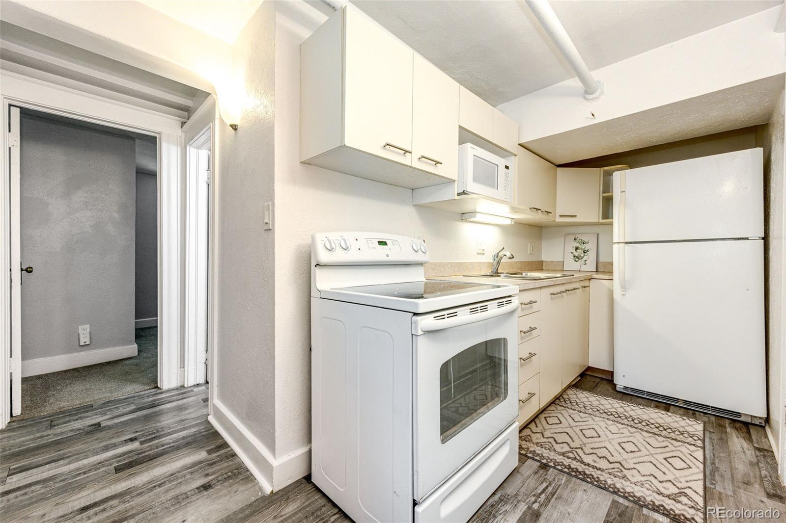 1401 Fillmore Street, Unit 5 Denver, CO 80206 - Photo 9 of 19 a kitchen with a white cabinets and white appliances