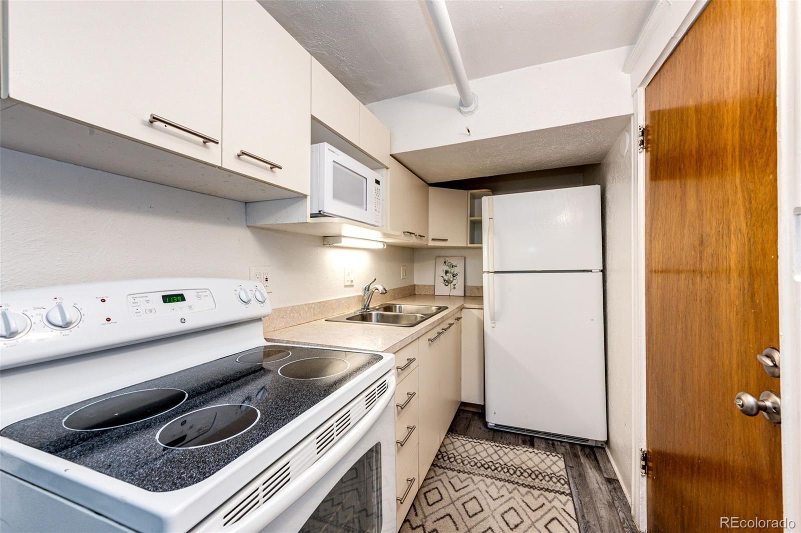 1401 Fillmore Street, Unit 5 Denver, CO 80206 - Photo 10 of 19 a kitchen with a sink a stove and a refrigerator