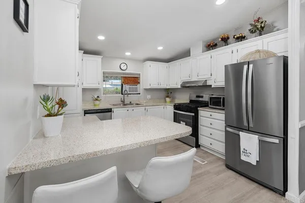 a kitchen with white cabinets and stainless steel appliances