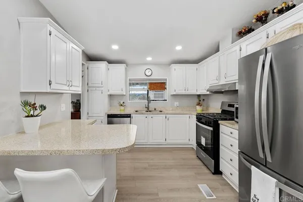 a kitchen with stainless steel appliances granite countertop a stove a sink and a refrigerator