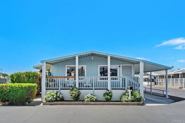 a view of a house with a yard and potted plants