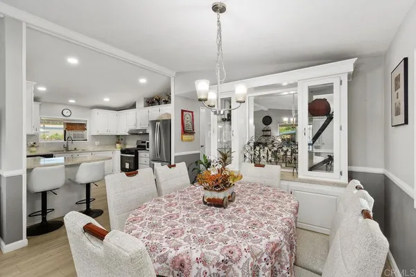 a living room with furniture kitchen view and a chandelier