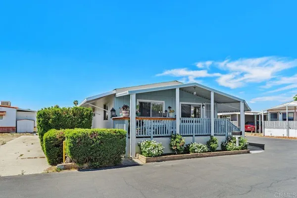 a front view of a house with a garden and plants