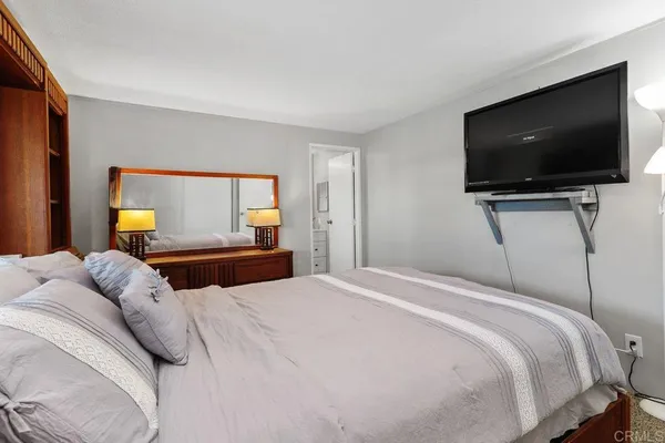 a bedroom with a bed a dresser and a window