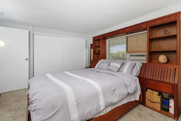 a bedroom with a flat screen tv and a walk in closet