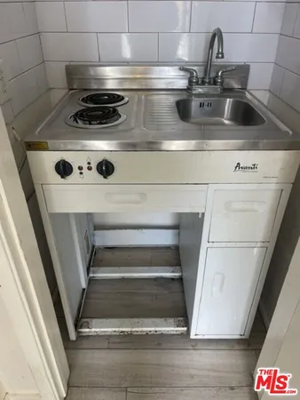a stove top oven sitting inside of a kitchen