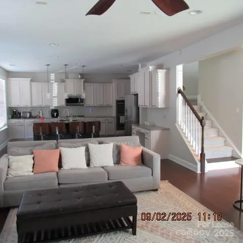 a living room with furniture and a view of kitchen
