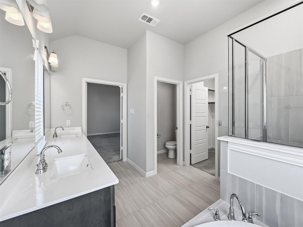 12632 Akenside Road Frisco, TX 75035 - Photo 20 of 40 a bathroom with a sink a mirror and a shower
