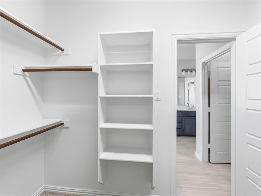 12632 Akenside Road Frisco, TX 75035 - Photo 26 of 40 a view of walk in closet with empty racks