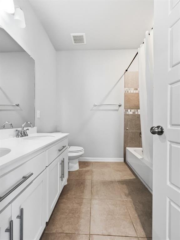 12632 Akenside Road Frisco, TX 75035 - Photo 36 of 40 Full bathroom featuring a double sink vanity with storage cabinetry, tile flooring, and a bathtub with shower combination.