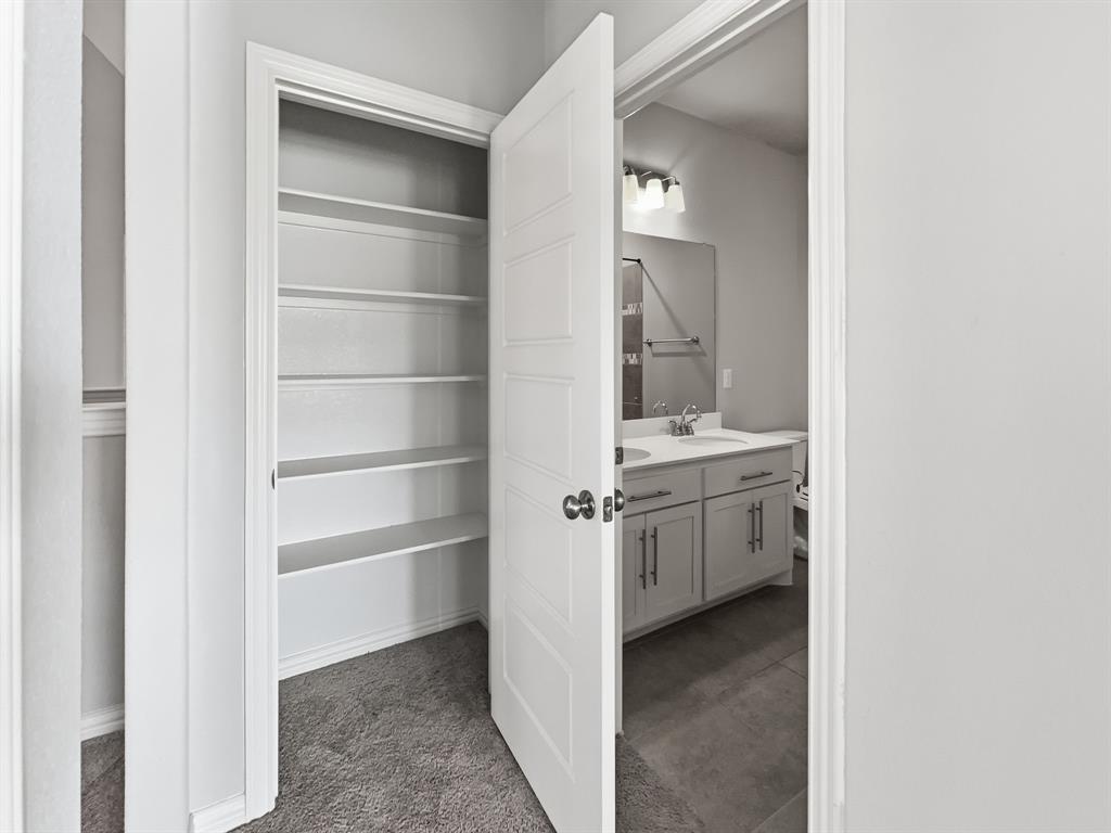 12632 Akenside Road Frisco, TX 75035 - Photo 37 of 40 a view of a kitchen with white cabinets and sink