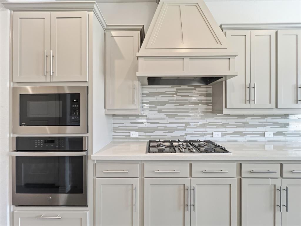 12632 Akenside Road Frisco, TX 75035 - Photo 4 of 40 a kitchen with granite countertop white cabinets and white appliances