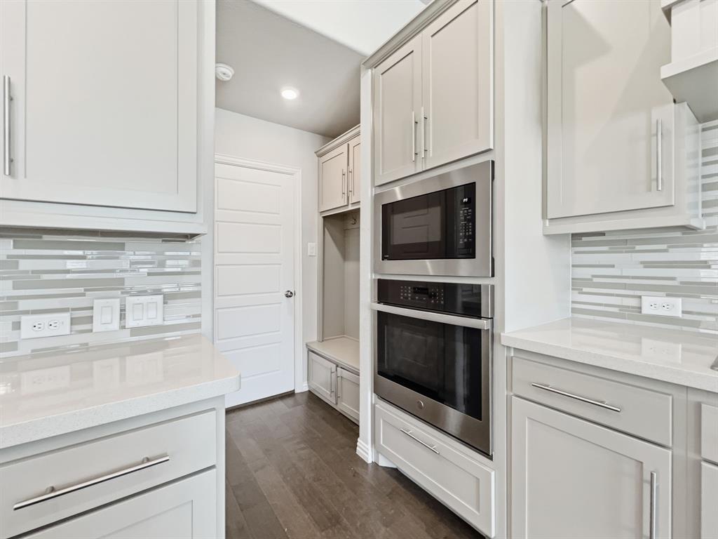 12632 Akenside Road Frisco, TX 75035 - Photo 5 of 40 a kitchen with stainless steel appliances white cabinets and a stove