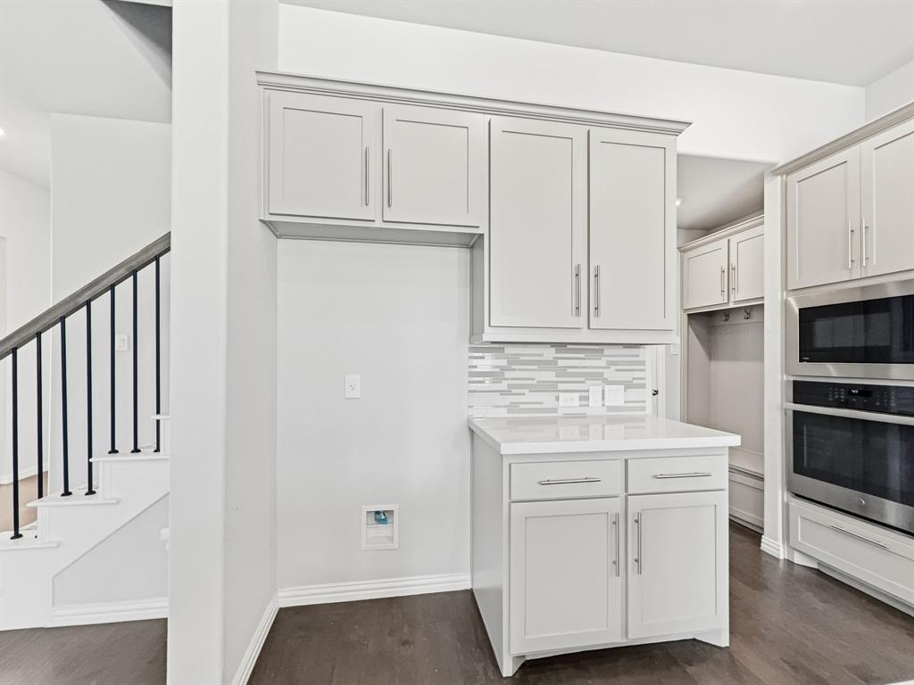 12632 Akenside Road Frisco, TX 75035 - Photo 6 of 40 a kitchen with white cabinets and white appliances