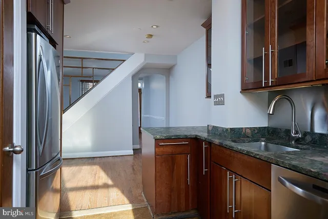 a kitchen with granite countertop a sink a stove and cabinets