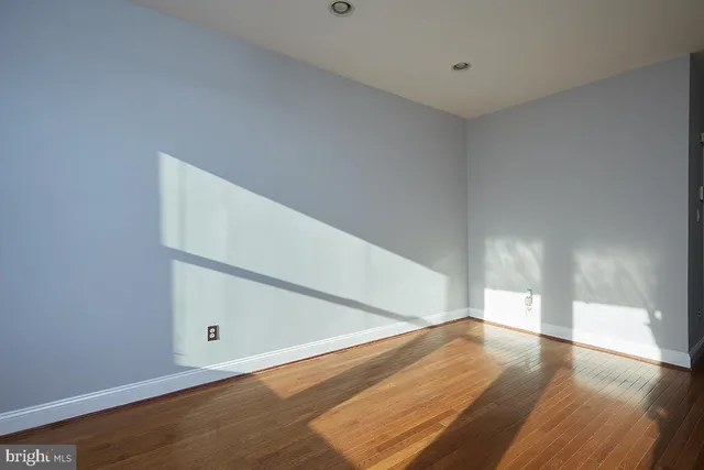 a view of empty room with wooden floor