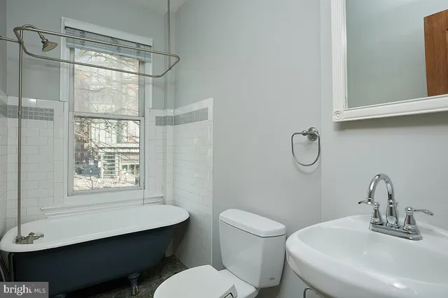 a bathroom with a sink toilet a mirror and shower
