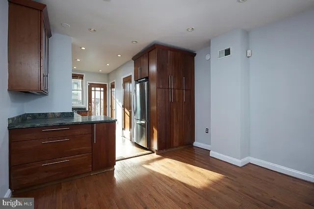 a view of kitchen with wooden floor and electronic appliances
