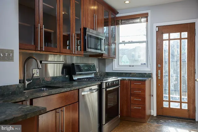 a kitchen with stainless steel appliances granite countertop a stove and a sink