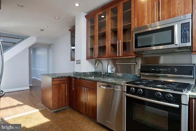 a kitchen with stainless steel appliances granite countertop a stove microwave and oven